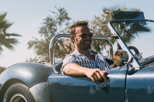 Preview: Man driving a convertible vintage car