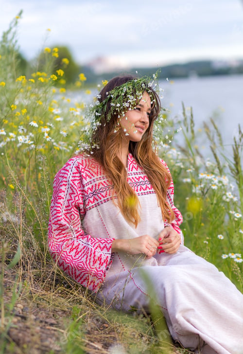 Preview: fashionable girl sits on the shore of the lake, river. Gen Z