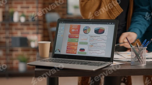 Preview: Close up of laptop with chart rate information on desk