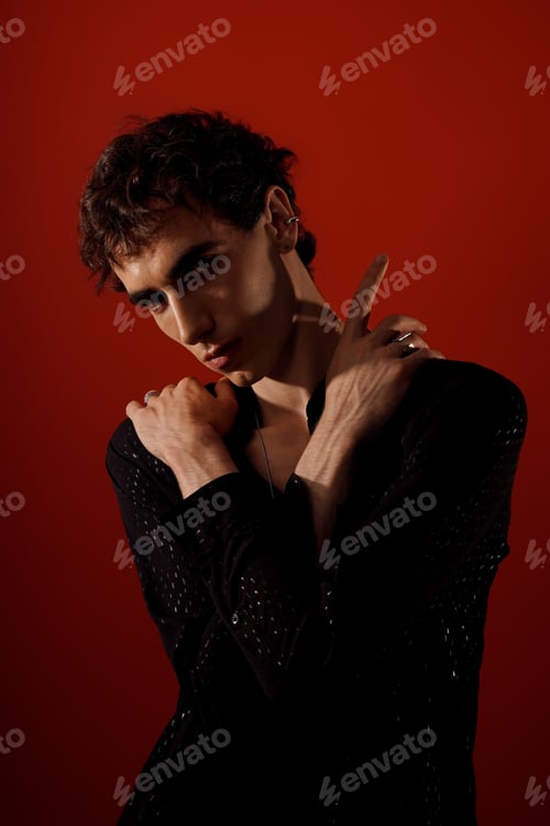 Preview: Stylish man poses elegantly against a vivid red backdrop showcasing his fashion sense