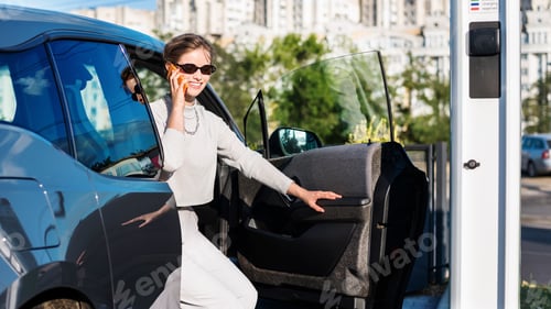 Preview: Young woman with an electric car at charging station in Chisinau, Moldova