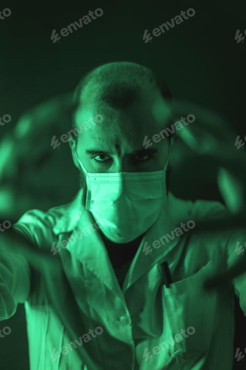 Preview: Vertical shot of a young male doctor wearing a medical mask looking powerful