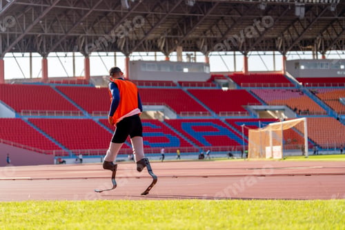 Preview: Asian para-athletes with prosthetic blades sprint on a running track at stadium.
