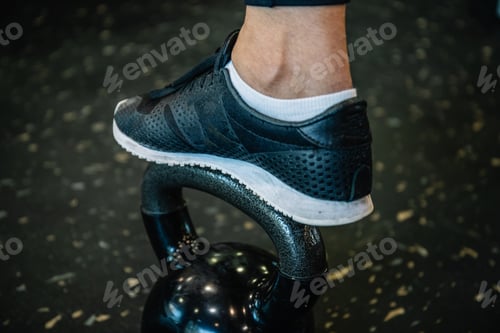 Preview: detail of a footwear with sports shoes on a kettlebel in the gym