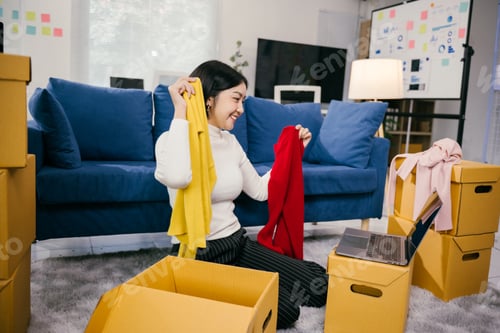 Preview: Online seller comparing clothes during live stream in startup office