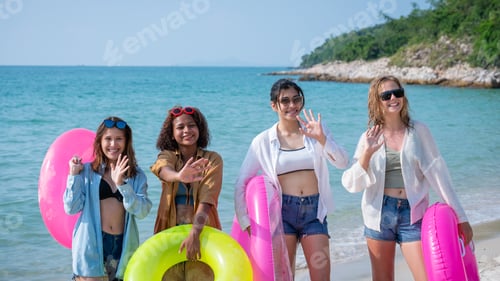 Preview: Group of diverse young women smiling on a sunny beach. Youth Friends Enjoying Sea Splash Together.