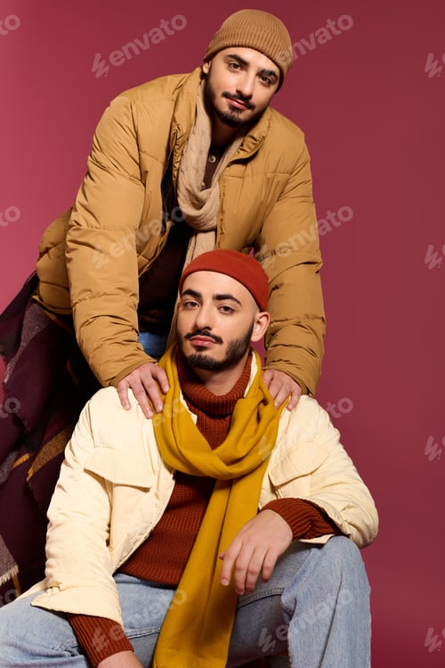 Preview: Stylish twins posing confidently in trendy outfits against a vibrant backdrop