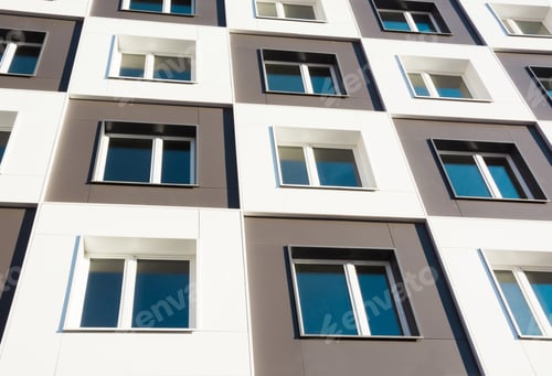 Preview: Modern and new apartment building. Photo of a tall block of flats against a blue sky.