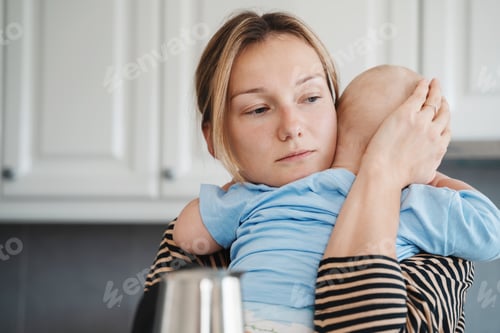 Preview: Loving mother hugging and comforting little baby.