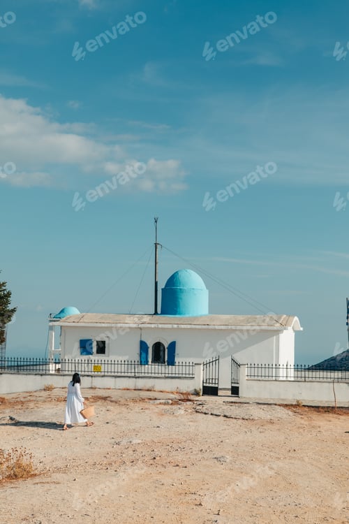 Preview: beautiful woman in white dress near old greece church