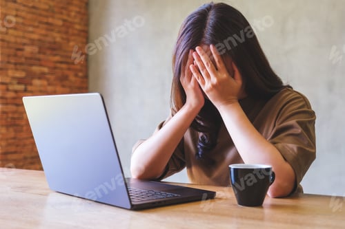Preview: A woman get headache and stressed while working online on laptop computer at home