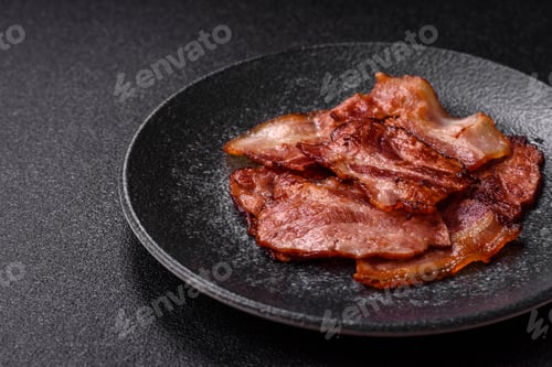Preview: Cooked fried crispy bacon as an ingredient of a delicious English breakfast. Pieces of fried bacon