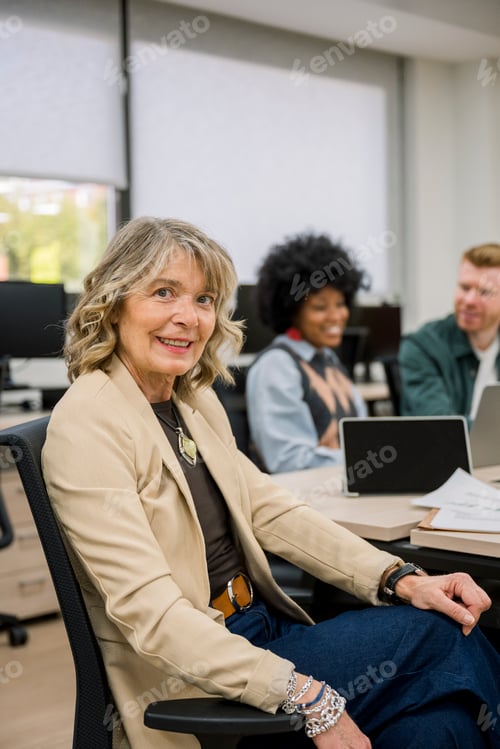 Preview: Senior businesswoman smiling at office meeting table