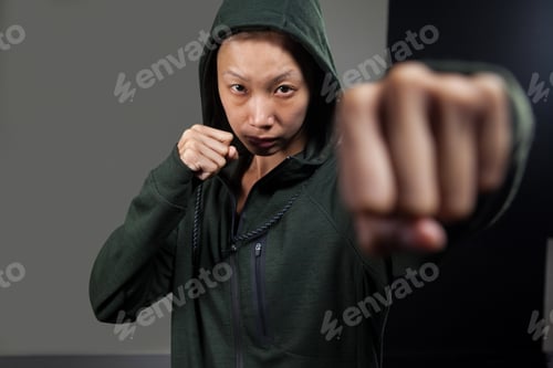 Preview: Determined woman practicing boxing in fitness studio