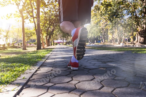 Preview: Young fitness man runner running on road in park. Running for lose weight and good health