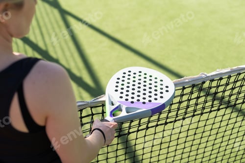 Preview: hands of a woman paddle player is holding balls and the racket at the background at the beginning of