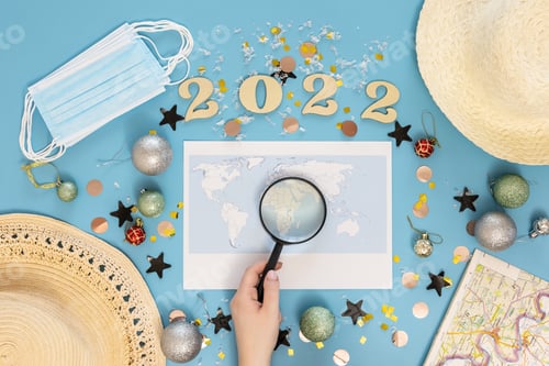 Preview: Travel flat lay composition with world map and numbers 2022 on blue background.