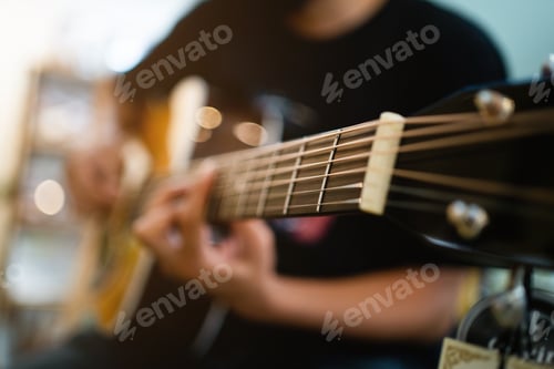 Preview: A man is playing a guitar with a black strap.