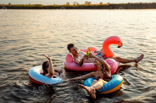 Preview: Group of young friends having fun and enjoying a summer day swimming.