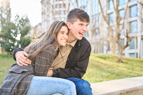 Preview: Young couple sharing laughter and joy, sitting on the street in unforgettable moments.