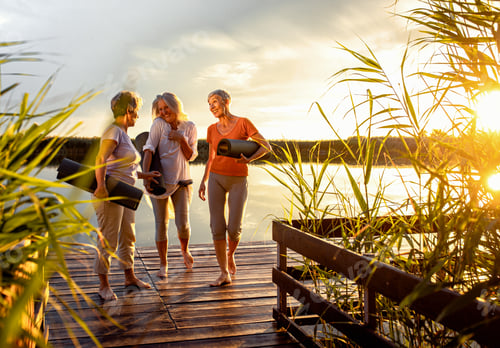 Preview: Group of senior woman with yoga mats talking after exercise.