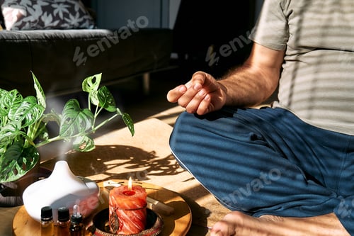 Preview: Overweight man practicing yoga and meditation at home sitting in lotus pose on yoga mat.