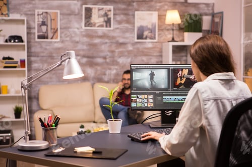 Preview: Creative female videographer working on a movie using her home computer