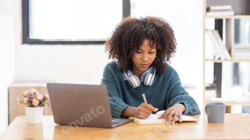 Preview: Young Woman Studying at Desk with Laptop
