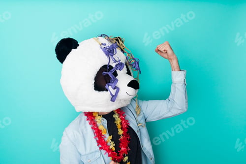 Preview: Excited man in panda mask with party ornaments celebrating on colored background