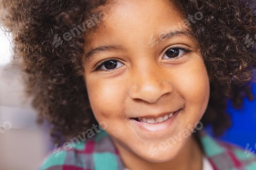 Preview: In school, young biracial boy is smiling at camera