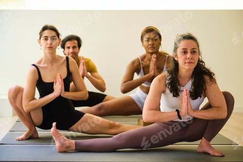 Preview: A group of people are doing utthita namaskarasana yoga pose on a mat.