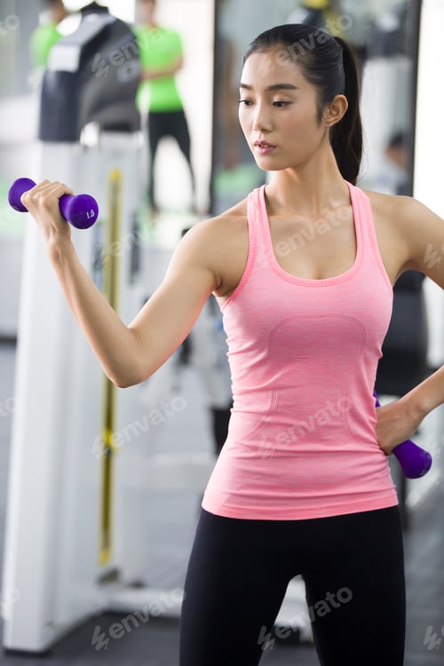 Preview: Young Chinese woman exercising at gym