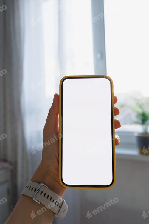 Preview: Close-up of human hand holding black white-screen mobile phone in interior background. mockup
