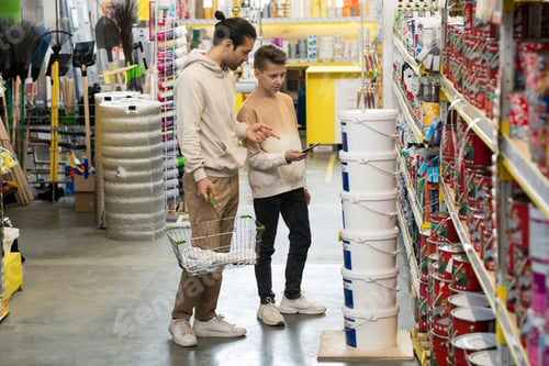 Preview: Father and son standing by one of displays in hardware store