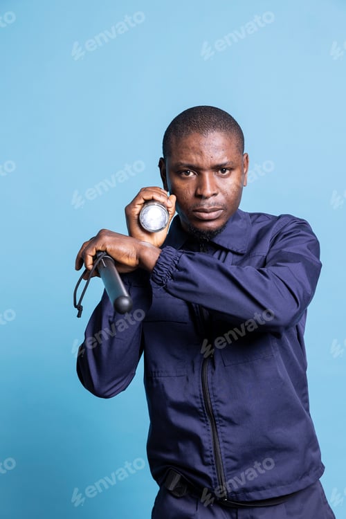 Preview: African american guard using a flashlight to inspect the premises
