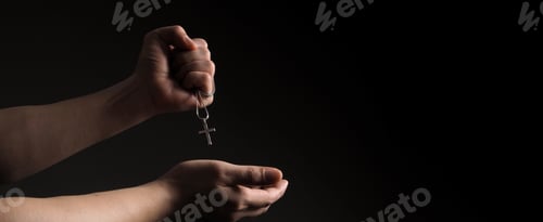 Preview: Crucifix pendant or cross sign made from silver and hold in man hand.