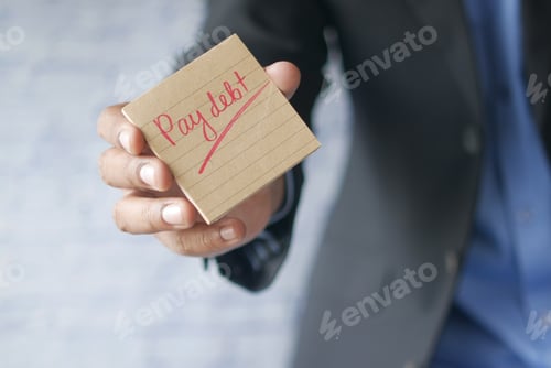 Preview: young man hand hold a sticky note with pay debt text