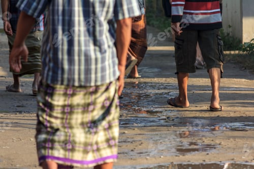 Preview: Group of men walking down a wet dirt road in Gili-Air