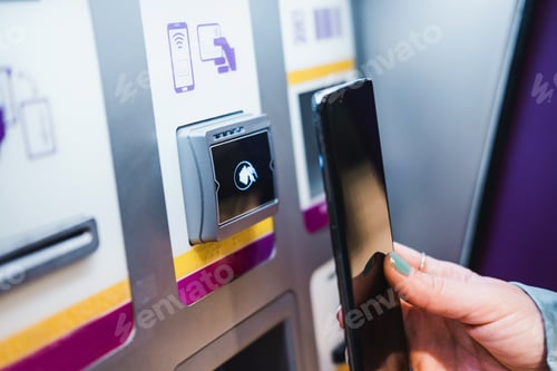 Preview: Close up of unrecognisable hand paying contact less by using smartphone