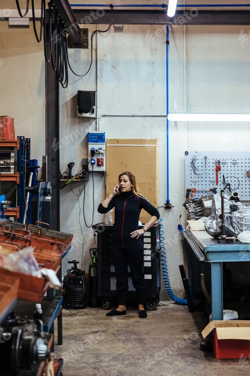 Preview: Woman talking on the phone in a mechanical garage