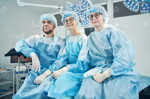 Preview: Medic sitting with female co-workers on operation bed