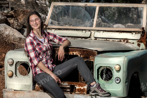 Preview: Smiling woman in sunglasses in old car between deserted lands