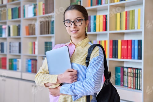Preview: Portrait of teenager student girl looking at camera in library