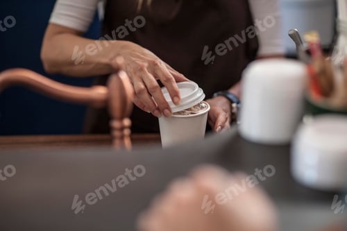 Preview: Barista closing lid of disposable coffee cup