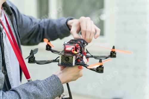 Adult Holding Drone with Orange Propellers Outdoors