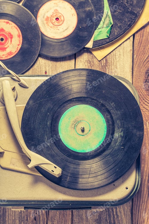 Preview: Old gramophone and few vinyl records on wooden table