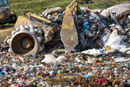 Preview: Heavy machinery shredding garbage in an open air landfill. Pollution