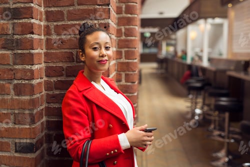 Preview: Portrait of woman in red coat in bar