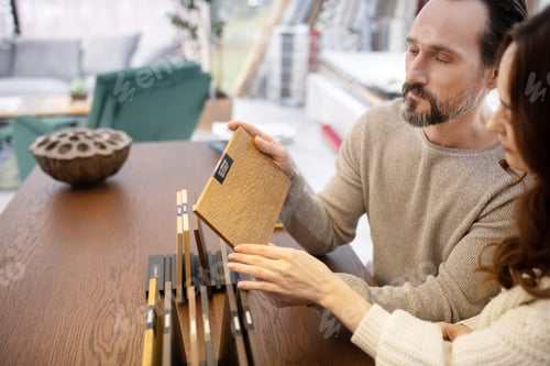 Preview: Wood In Hands. Man And Woman In Light Sweaters Looking Involved