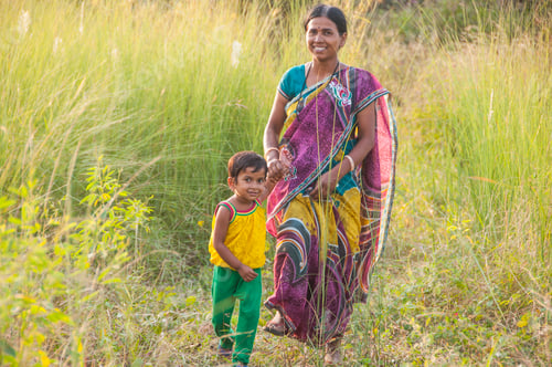 Preview: Portrait of happy mother and daughter in meadow at sunset.